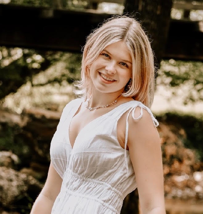 Jules in a white shirt smiling